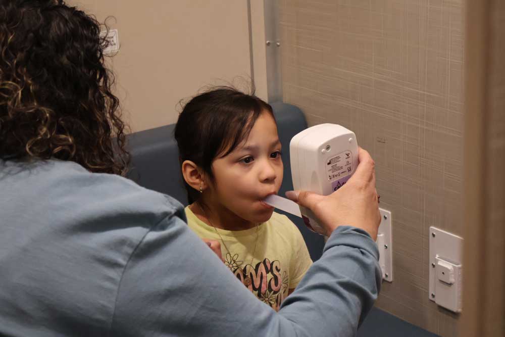 A young patient undergoes a FeNO test inside the Asthma Van, helping the care team assess and personalize her asthma treatment plan.